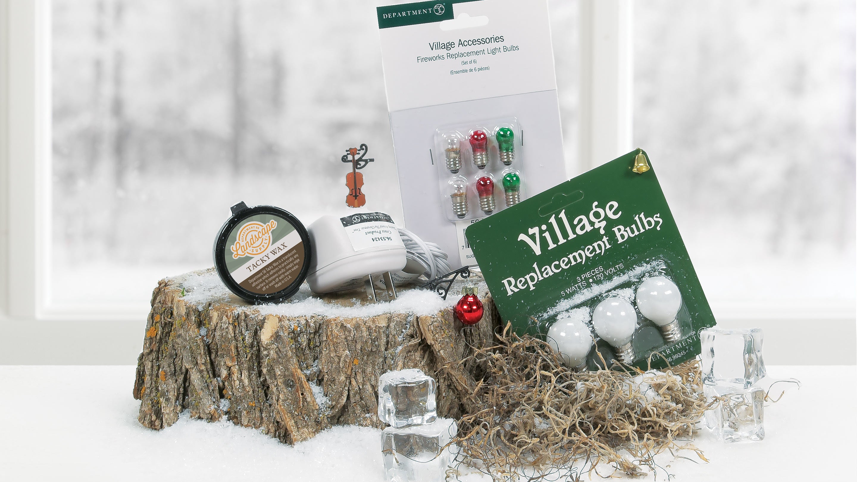 Christmas village accessories including bulbs and lights on a snowy background