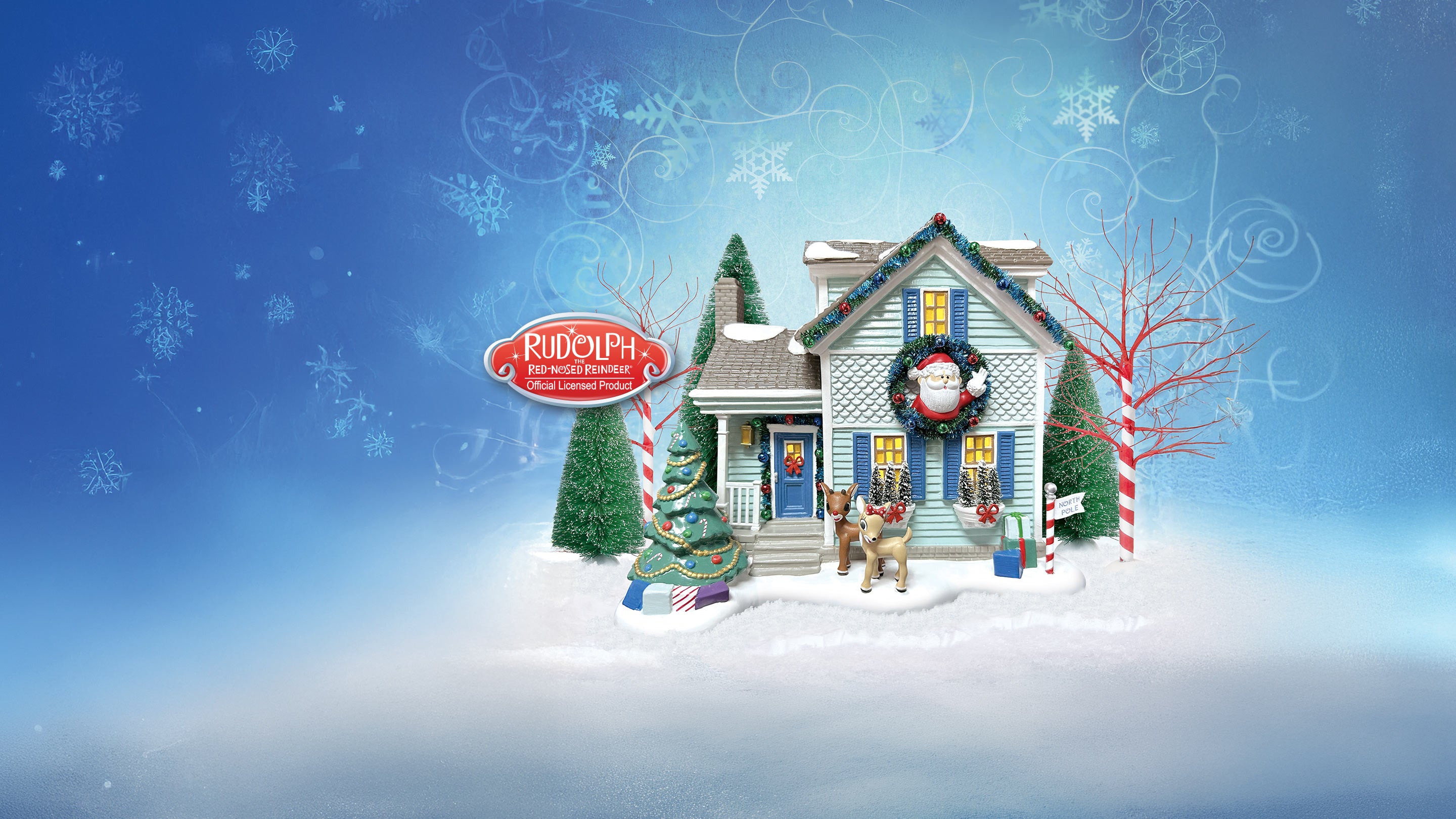 A festive Christmas village scene featuring a small snow-covered house decorated with a Santa wreath, candy cane signs, evergreen trees, and holiday ornaments, set against a blue snowy background with decorative swirls.