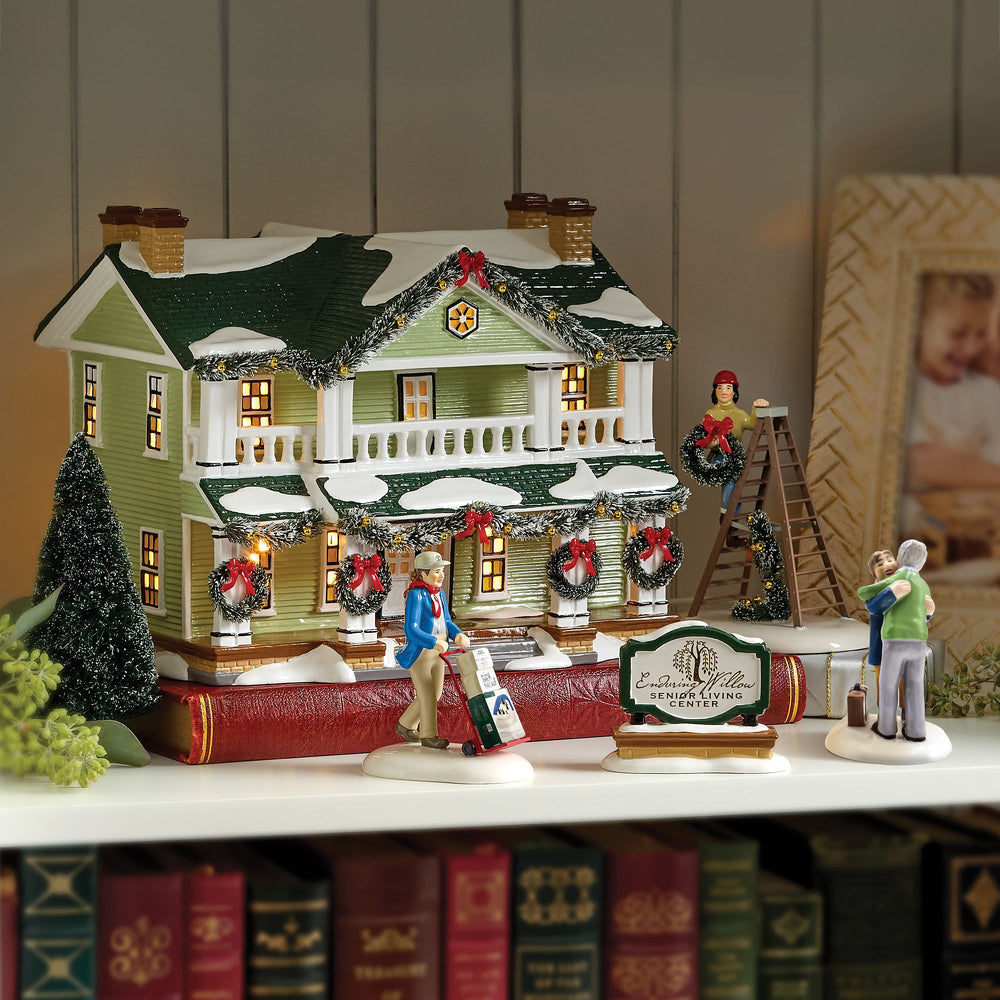 A classic ceramic house from the Department 56 Original Snow Village collection, featuring warm lighting and snowy details.